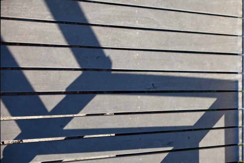 Schatten auf der Holztreppe zum Strand bei Mornington